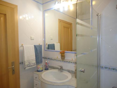 a bathroom with a sink and a mirror at Vilas do Mar in Carvoeiro