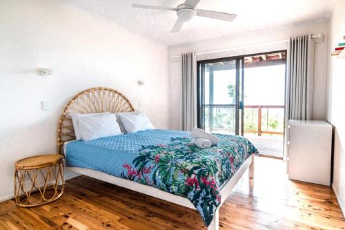 ein Schlafzimmer mit einem Bett mit einer blauen Decke in der Unterkunft Beach Buoys in Point Lookout