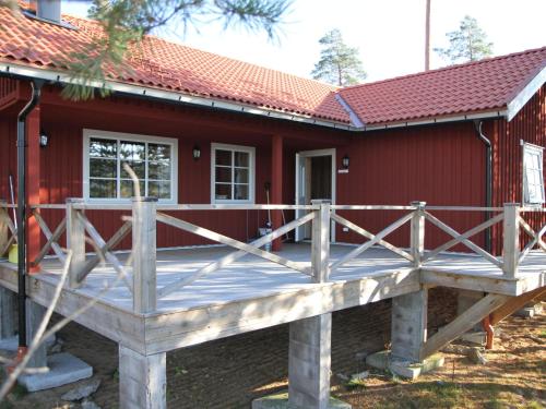 una terraza frente a una casa roja en Chalet in Torsby Municipality Middle with Sauna, en Gunsjögården