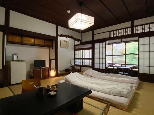 a room with a bed and a table in it at Ryoso Kawaguchi in Miyajima