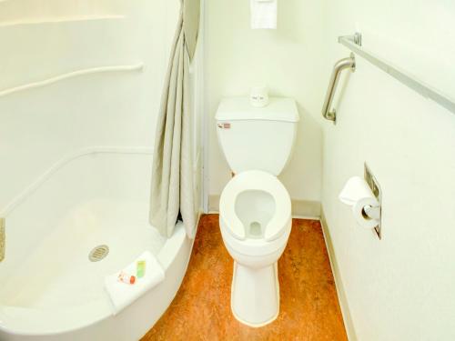 a bathroom with a toilet and a bath tub at Travelodge by Wyndham Miles City in Miles City
