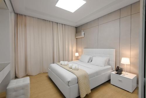 Un dormitorio con una cama blanca con dos velas. en Elite apartments en Astaná