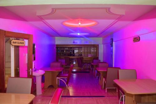 różowy pokój ze stołami i krzesłami w restauracji w obiekcie TAITA LUXURY HOTELS LTD w mieście Wundanyi