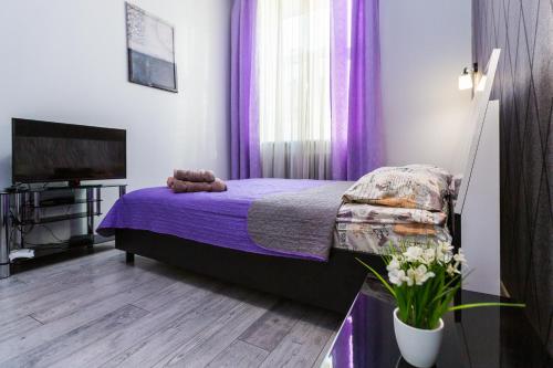 una camera da letto con letto con tende viola e camino di 8 Svyatoho Teodora Square Apartments a Lviv