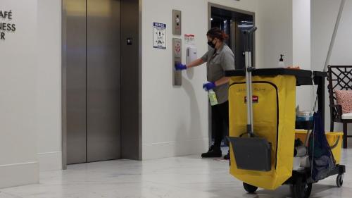 a man with a mask and gloves is pushing a yellow cart at YO1 Longevity & Health Resorts, Catskills in Monticello