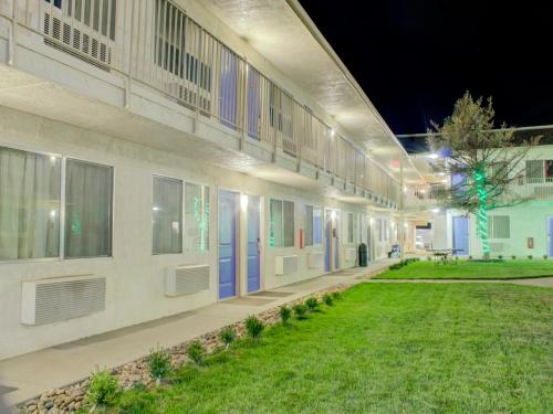 a building with blue doors and a grass yard at Travelodge by Wyndham Miles City in Miles City