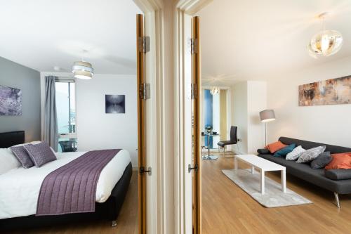 米爾頓凱恩斯的住宿－Brightleap Apartments - The Hub，一间卧室配有一张床和一张沙发