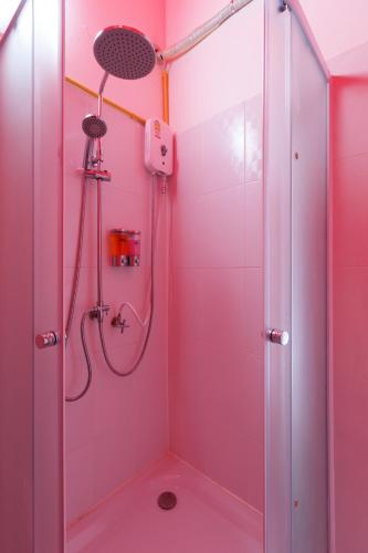 a pink bathroom with a shower with a shower head at Ozone by บ้านเขาค้อ in Phetchabun