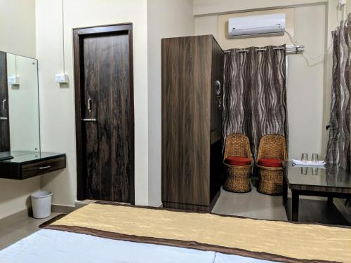 a room with a bed and a table and a door at Townhouse - The Urban Inn in Dibrugarh