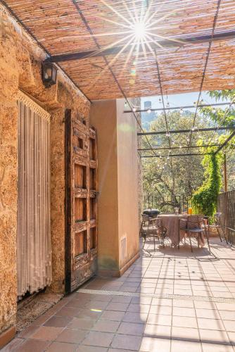 an outdoor patio with an open door and a table at Ca La Conxita in Las Escaulas