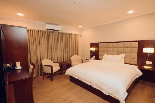 a hotel room with a bed and a table and chairs at Hotel King's Palace in Lubumbashi