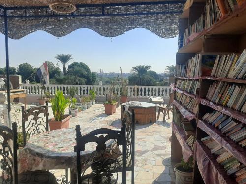 um quarto com uma mesa e uma estante de livros com livros em Luxor Bella Vista Apartments and Hotel em Luxor