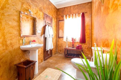 a bathroom with a sink and a toilet in it at Kibanda Natural Kendwa Villa in Kendwa