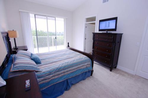 Un dormitorio con una cama y un televisor sobre una cómoda. en 456 Little Harbor, en Ruskin