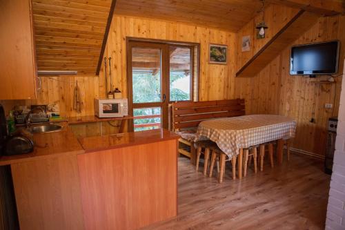 a kitchen and dining room with a table in a cabin at Kryvorizka Palanka in Mykulychyn