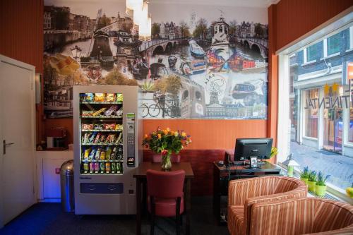 a room with a refrigerator and a wall with a mural at Hotel Continental Amsterdam in Amsterdam