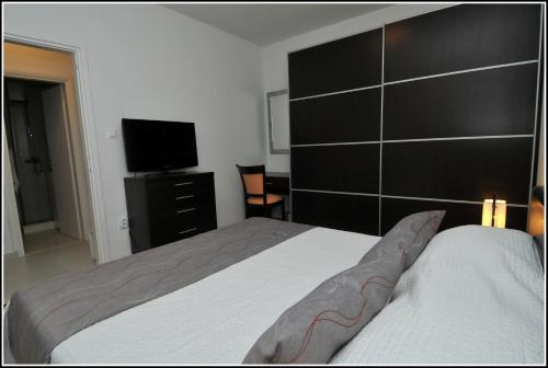a bedroom with a bed and a flat screen tv at Apartment Karmen in Dubrovnik