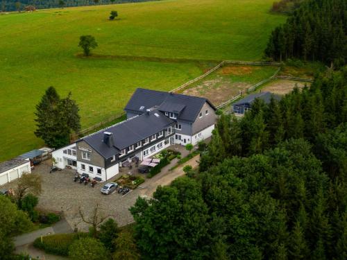 eine Luftansicht eines großen Hauses auf einem Feld in der Unterkunft Wittgensteiner Landhaus Winterberg in Winterberg