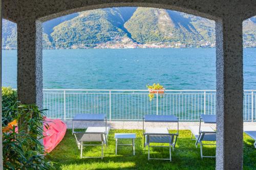 a view of the water from a balcony with chairs at Bellagio Villas in Lezzeno