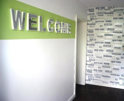 a wall with a welcome sign in a room at Modernes-Wohnen-im-Bungalow in Quickborn