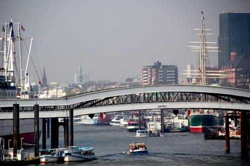 a bridge over a river with boats in a city at Modernes-Wohnen-im-Bungalow in Quickborn