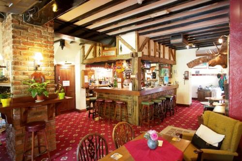 un restaurante con bar y algunas mesas y sillas en Abbey Grange Hotel, en Llangollen