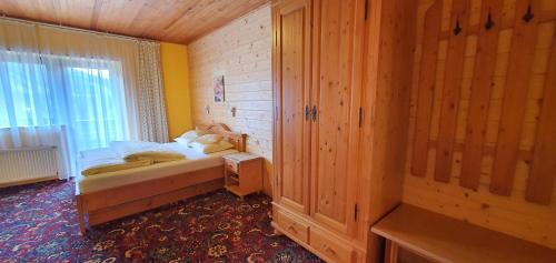 a small bedroom with a bed and a window at Pension Vinkl in Harrachov