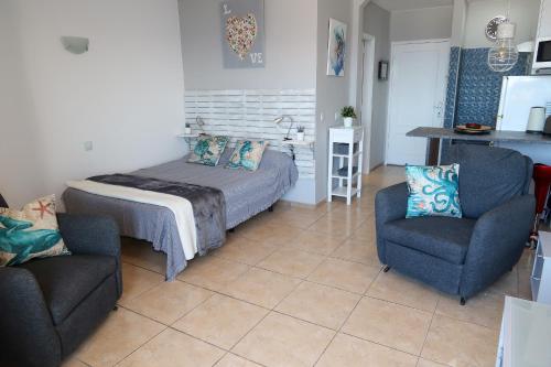 Un dormitorio con una cama y dos sillas. en Ocean View Deluxe Studio, en Playa Paraiso