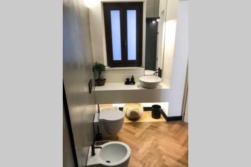 W łazience znajduje się toaleta, umywalka i lustro. w obiekcie BellaVita - Confort e Raffinatezza in Centro Città w Katanii