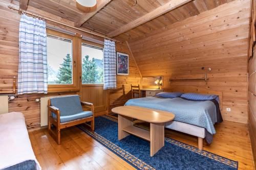 a bedroom with a bed and a table and a chair at Willa Koisowka in Zakopane