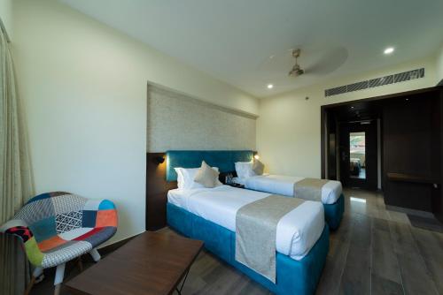 a hotel room with two beds and a chair at ICON Boutique by Bhagini in Bengaluru