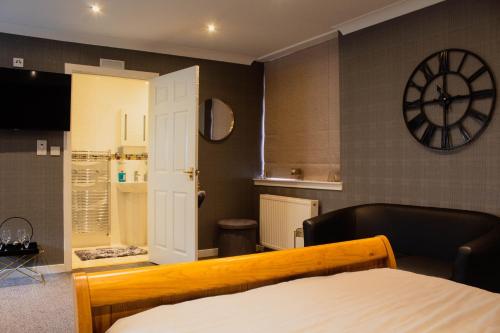 Habitación con cama y reloj en la pared en Forth Apartments en Kirkcaldy