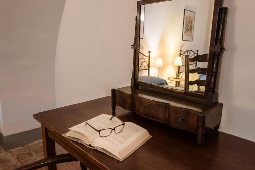 an open book on a wooden table with a mirror at Agriturismo San Ottaviano in Monterotondo