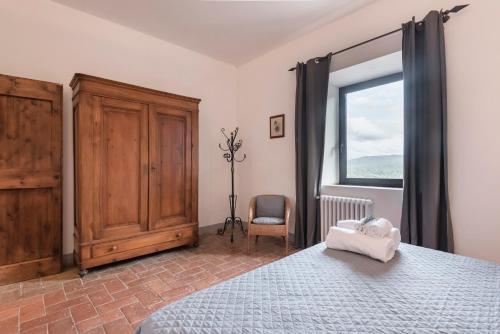 a bedroom with a bed and a window and a chair at Agriturismo San Ottaviano in Monterotondo