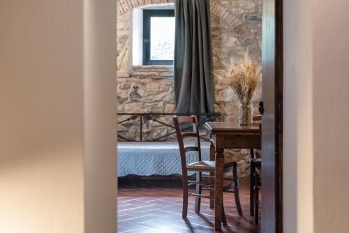 a dining room with a table and a bedroom at Agriturismo San Ottaviano in Monterotondo