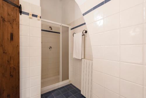 a bathroom with white tiled walls and a shower at Agriturismo San Ottaviano in Monterotondo