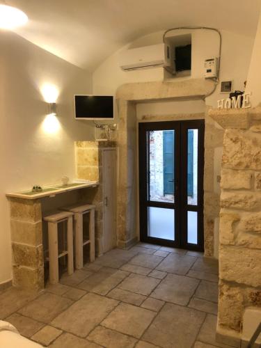 a room with a door and a tv on the wall at Casetta dello Scrittore in Ostuni