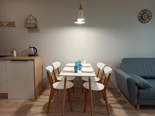 a table and chairs in a kitchen with a blue couch at Apartament Września II in Września