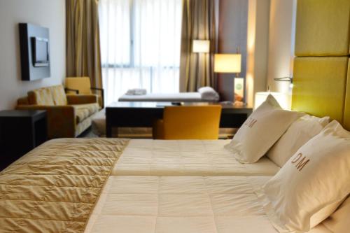 a hotel room with a bed and a living room at Gran Hotel Don Manuel in Cáceres