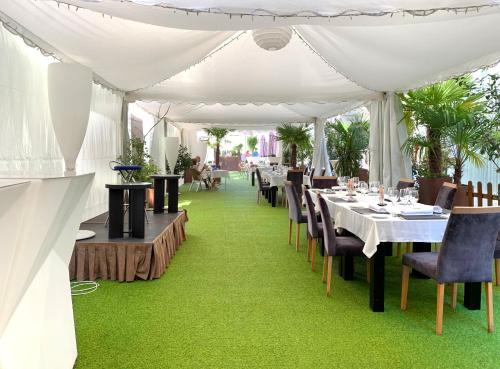 a white tent with tables and chairs on green grass at Gran Hotel Don Manuel in Cáceres
