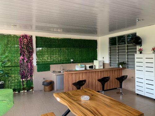 a kitchen with a table and some green walls at Loft 3 in Padang Besar