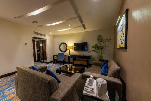 a living room with two couches and a table at Al Ghufran Safwah Hotel Makkah in Makkah