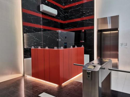 a bathroom with a red partition with black tile at G Square Residences in Manila