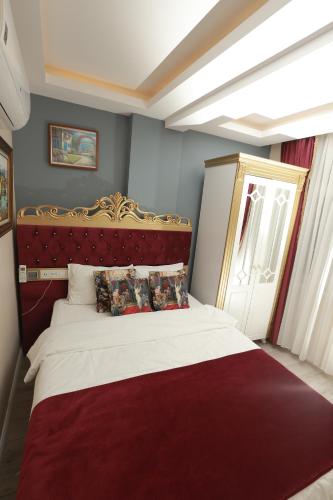 a bedroom with a large bed with a red headboard at Constantinopolis Hotel in Istanbul
