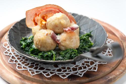 a plate of food with a doughnut and greens at Hotel La Serenella in Moena