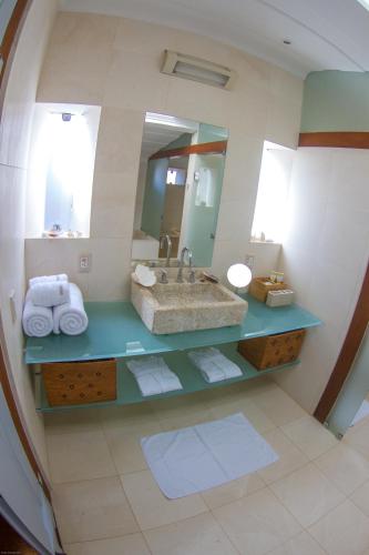 a bathroom with a sink and a mirror at Casa Simone Pousada in Paraty