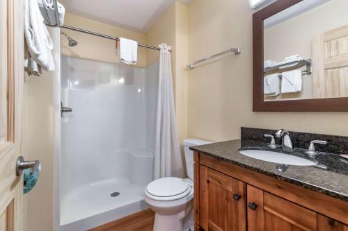 Un baño con inodoro, lavabo y ducha. en Rodeway Inn Lake George Outlets, en Lake George