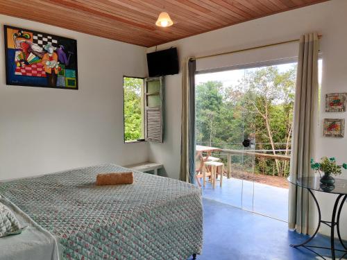 a bedroom with a bed and a sliding glass door at Lençóis Apartamento Suíte Master Green in Lençóis