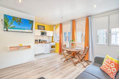 a living room with a table and a kitchen at Foyal Suites in Fort-de-France