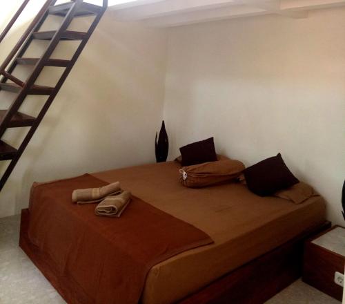 1 dormitorio con 1 cama grande y escalera en RIKNA BEACH HOUSE, en Watukarung